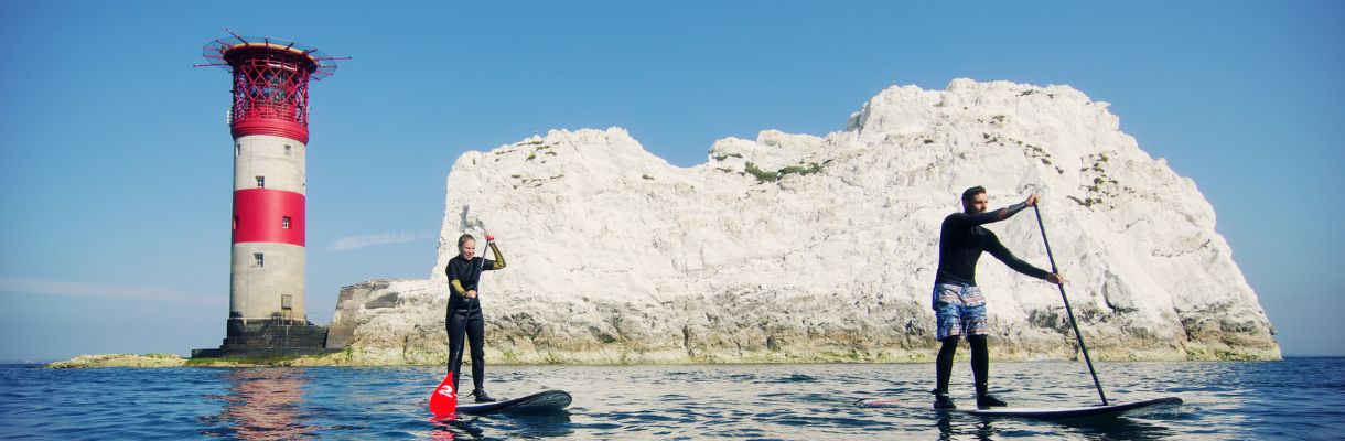 Two people paddleboarding around The Needles, Isle of Wight